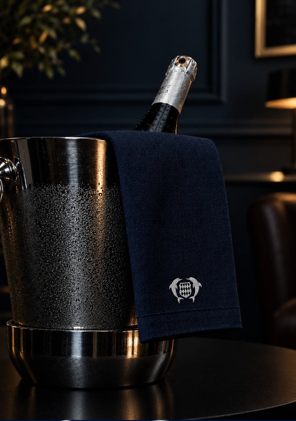 Champagne chilling in an ice bucket with a navy towel